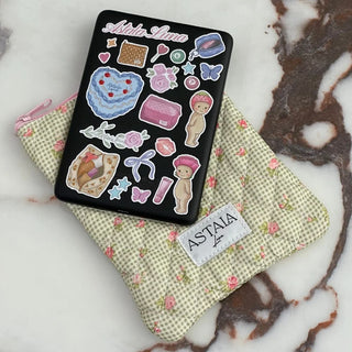 Kindle with cute stickers resting on a floral quilted pouch for sale at Astala Luna